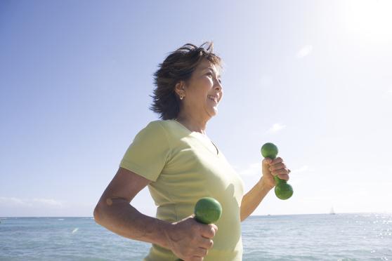 Woman walking on beach with weights